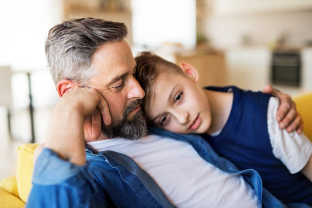 istock Mature father with small son sitting on sofa indoors, resting. 1155700971