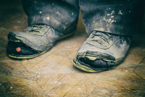 istock Old torn boots on the man's feet 1155701115