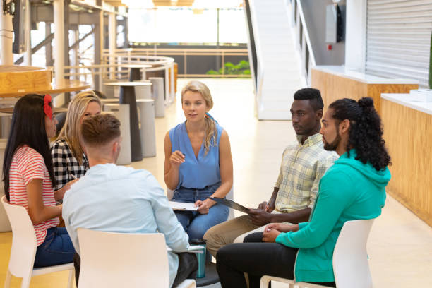 istock Business people sitting together and having a group discussion in a modern office 1155702653