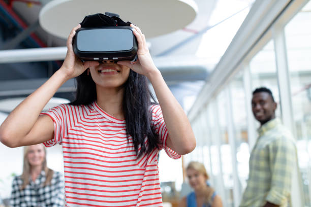 istock Businesswoman using virtual realty headset while diverse colleagues standing in background 1155705596