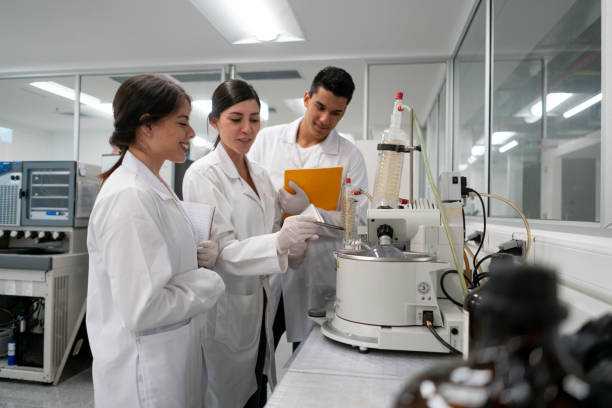 istock Group of biology students at the lab discussing an experiment 1155707578