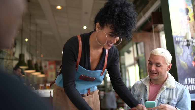 Waitress serving dish to couple in a restaurant