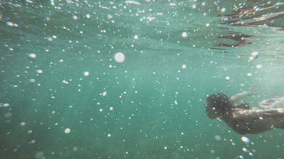 East Asian woman diving in the deep and crystalline waters in Adriatic sea in Split, Croatia