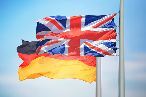 The British and German flags against the background of the blue sky
