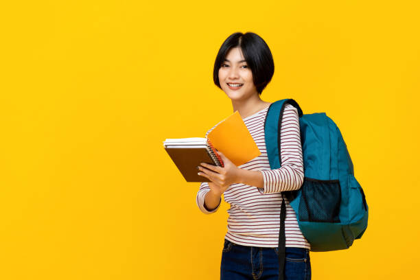 istock Asian female college student with backpack holding books 1155716730