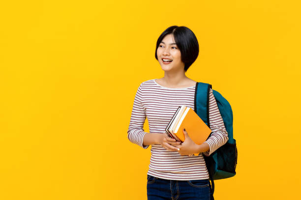 istock Asian female college student with backpack holding books 1155716733