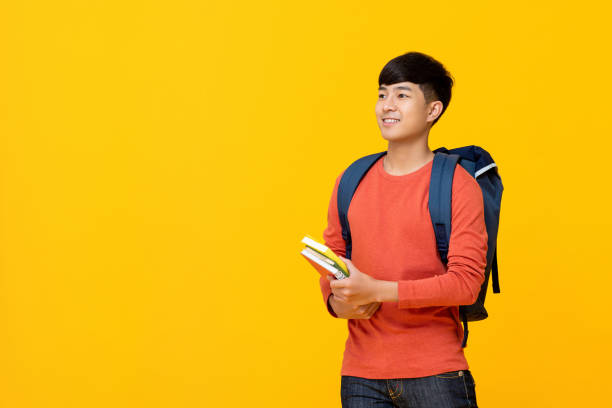 istock Asian male college student with backpack holding books 1155717051
