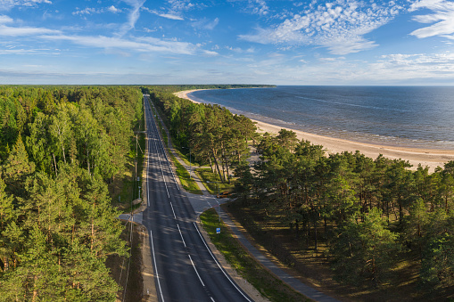 Car route Riga-Tallinn on a summer evening, along the coast of Baltic Sea. Perspective from a flying drone.