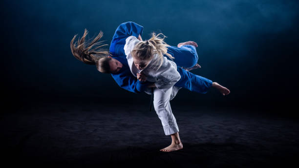 judo tiro sobre fondo negro - judo fotografías e imágenes de stock