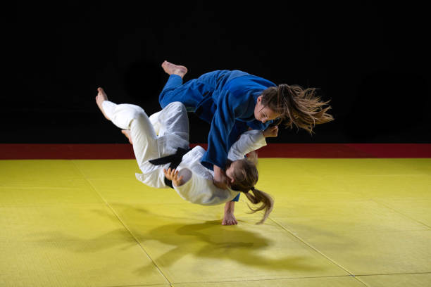 istock Female judo practitioner throwing her partner to the ground 1155720803