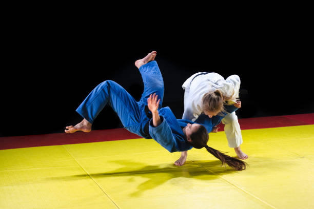istock Female judo practitioner throwing her partner to the ground 1155720810