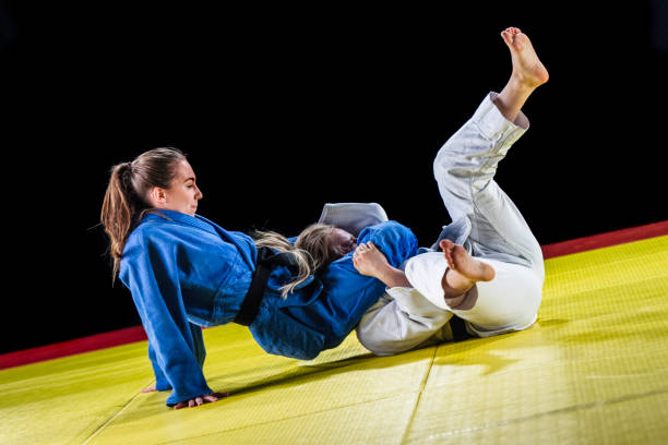 istock Female judoka choking her sparring partner with her legs 1155720811