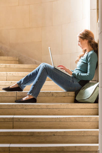 istock Young woman female college university student with laptop computer studying on campus 1155720896