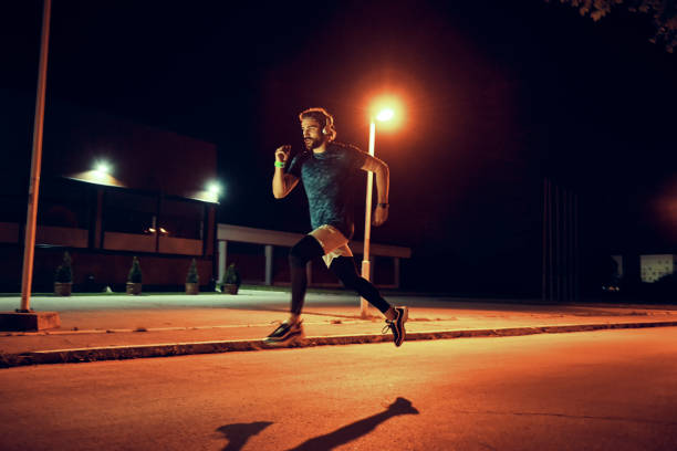 istock fit young man running at night 1155722399