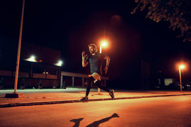 istock athletic man running late night in the city 1155722419
