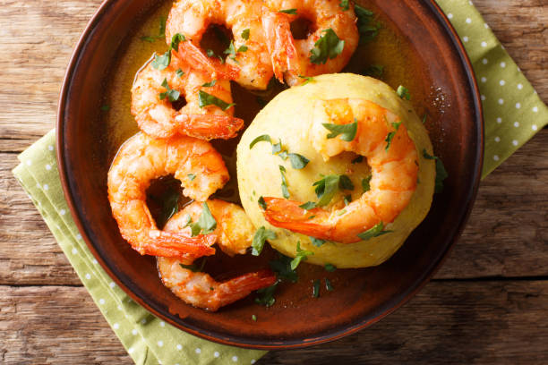 istock Mofongo (Garlic-Flavored Mashed Plantains): a very tasty dish served with shrimp close-up on a plate. Horizontal top view 1155722741