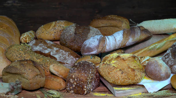istock Lots of mixed bread and buns on the table in the bakery. 1155722763