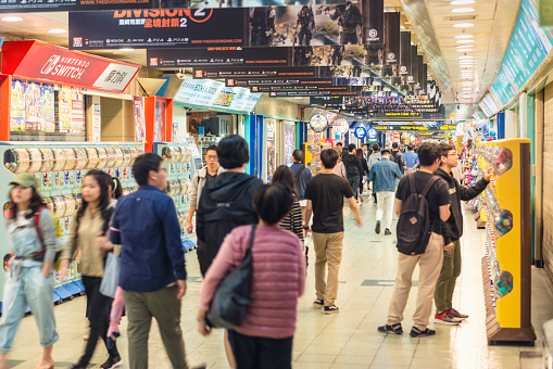 Horizontal color image of the famous Taipei City Mall in Taipei, Taiwan. Stores are visible on right and left, while most of them are selling electronics products. People are on the move, some of them are stopping by to observe the merchandises.