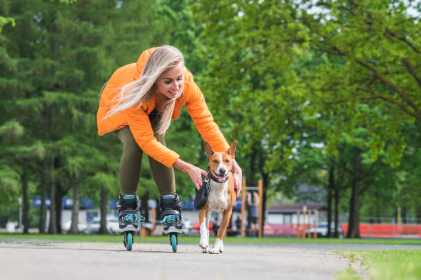 istock Young woman rolling on roller skates with a dog 1155732901