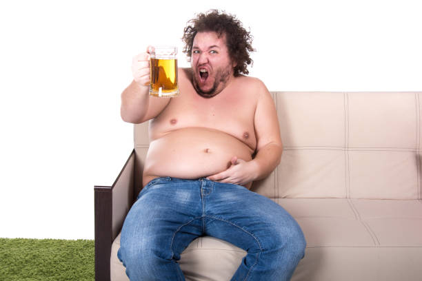 istock Funny fat man watching tv at home. 1155733151