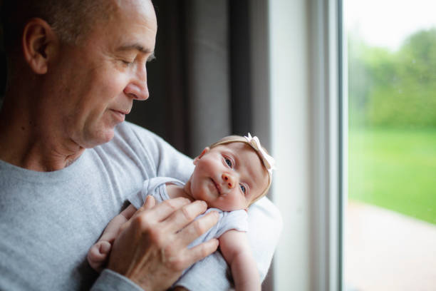 Cute newborn girl with parents and grandparents stock photo
