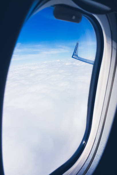 Dublin, Ireland - May 9, 2019 View from the Ryanair plane window to the airplane wing, clouds and sky during the flight