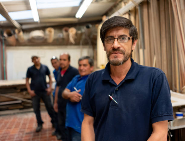 istock Group of carpenters working at a wood workshop 1155739082
