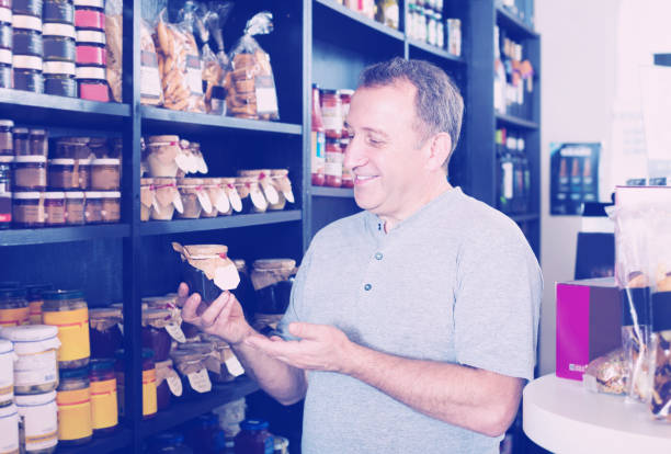 istock Mature man customer purchasing in delicatessen section 1155741565