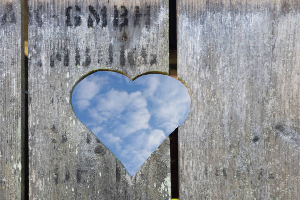 Wooden Door with heart shape looking in sky with clouds