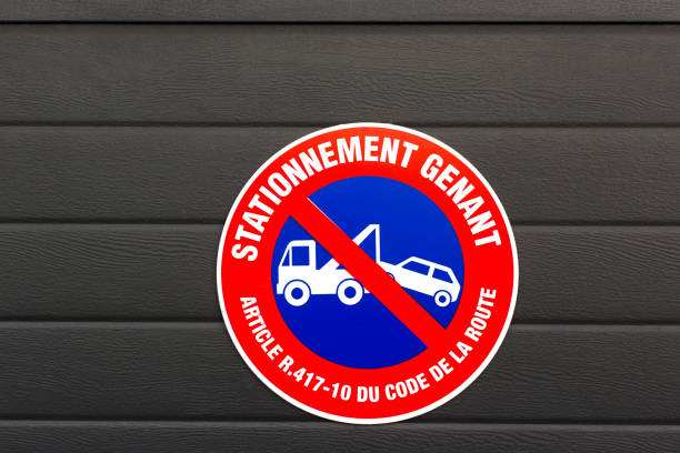 French Sign: "Stationnement Genant" (Tow-Away Zone) French Sign: "Stationnement Genant" (Tow-Away Zone). Black background with copy space. no parking sign photos stock pictures, royalty-free photos & images