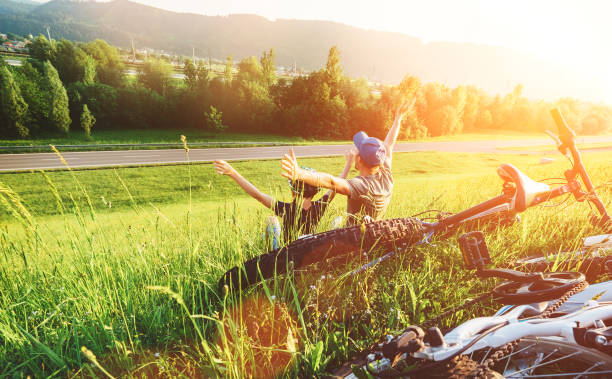 istock Father and son rest together in green grass when have bicycle walk 1155748056