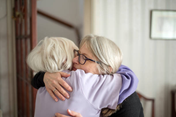 addio emotivo, madre e figlia si abbracciano. - consoling close up senior adult grandparent foto e immagini stock