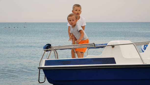 istock Two cute boys on the boat in the sea 1155751916