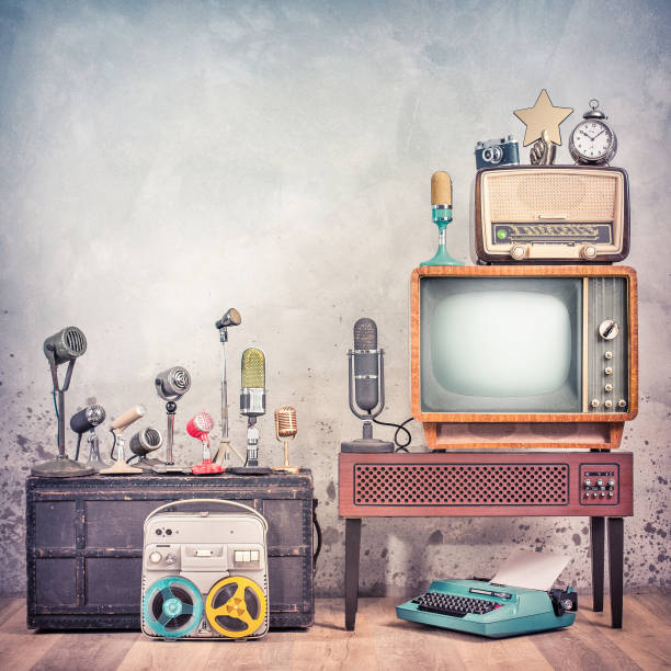 Retro studio microphones set, outdated TV, old broadcast radio, journalist's reel to reel tape recorder, aged clock, film camera, golden award star, typewriter. Journalism concept. Vintage style photo conjunto de micrófonos de estudio retro, tv obsoleta, radio de transmisión antigua, grabadora de carrete a carrete de periodista, reloj envejecido, cámara de cine, estrella de premio de oro, máquina de escribir. concepto de periodismo. foto de estilo v