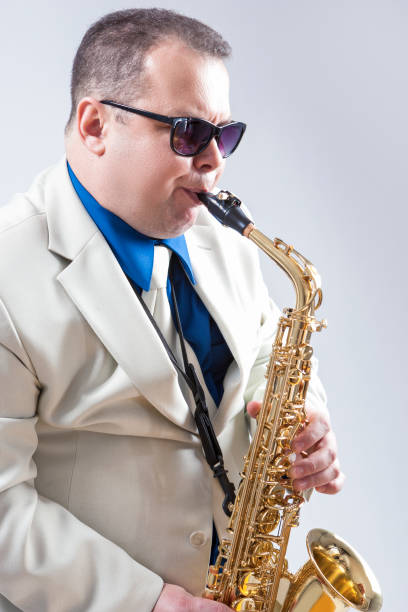 istock Male Saxo Player in Sunglasses Performing Expressively in Studio. Vertical Image Orientation 1155752733