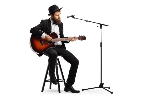 istock Man playing an acoustic guitar with a microphone in front of him 1155753033