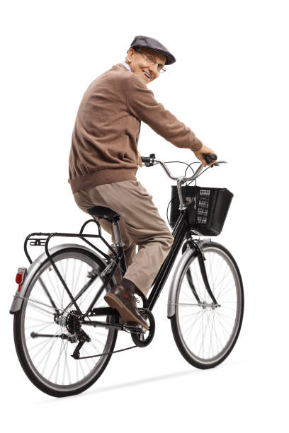 istock Cheerful senior man riding a bicycle and smiling at the camera 1155754460
