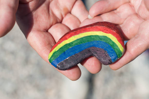 istock rainbow painting on stone pebble in hand 1155756832