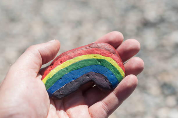 istock rainbow painting on stone pebble in hand 1155756833