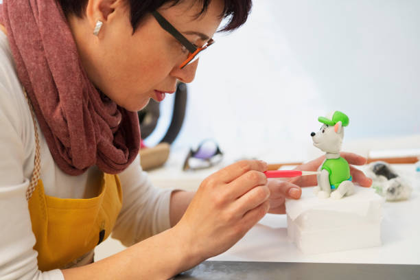 istock Close up of confectioner decorating figurine for a cake 1155758070