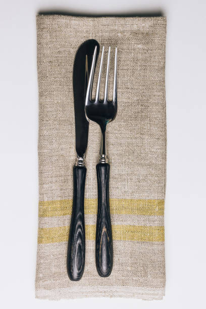 istock Fork, knife and linen napkin on white background. 1155763781