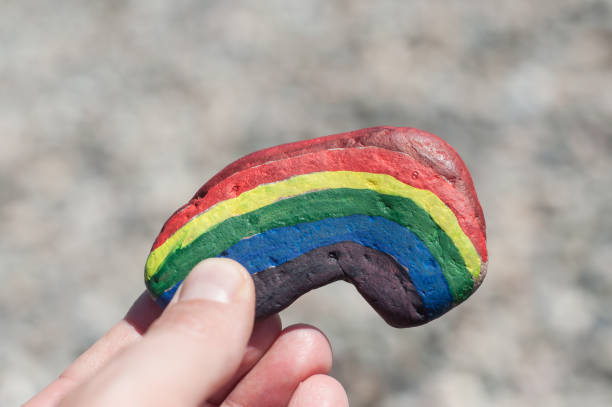 istock rainbow painting on stone pebble in hand 1155769609