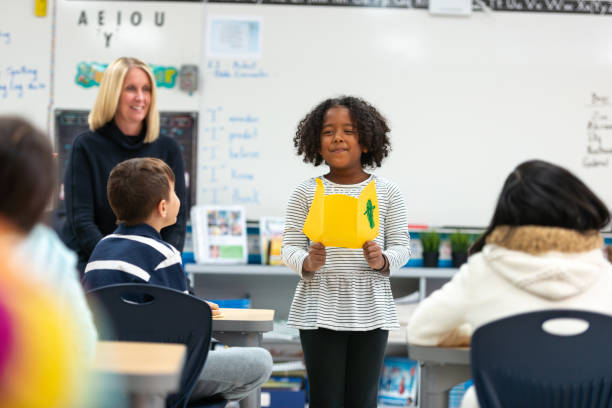istock Young African Girl Presenting to Her Class 1155771724