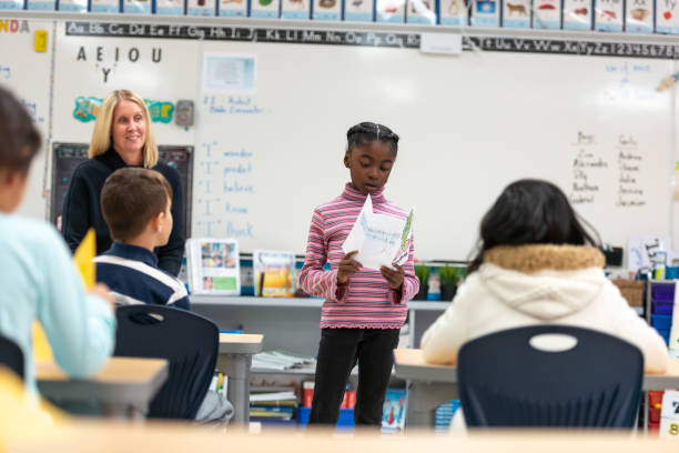 istock Young African Girl Presenting to Her Class 1155771728