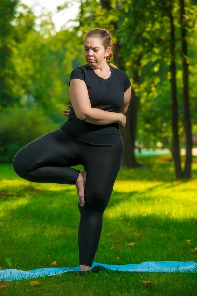 istock Young woman doing yoga exercise outdoors 1155771888