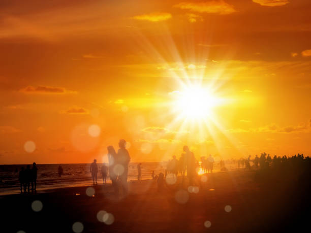 istock silhouetted people on public beach over orange colored sunset sky 1155772281