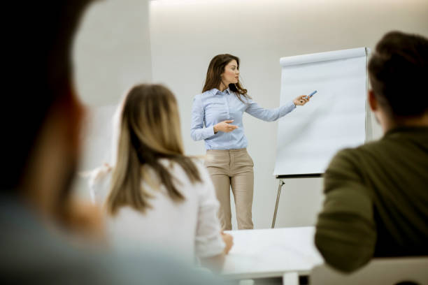 istock Creative positive female leader talking about business plan with students during workshop 1155774282
