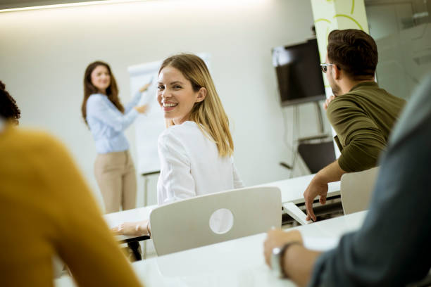 istock Creative positive female leader talking about business plan with students during workshop 1155774294