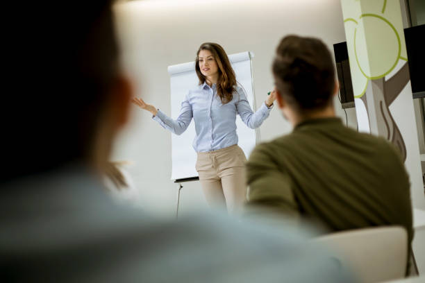 istock Creative positive female leader talking about business plan with students during workshop 1155774300