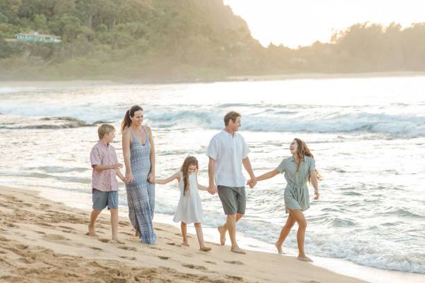 istock Family walking together on the beach 1155775728